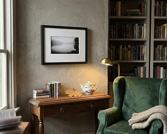 Gerahmte Schwarz-Weiß-Fotografie eines Waldsees in klassischem Wohninterieur.
