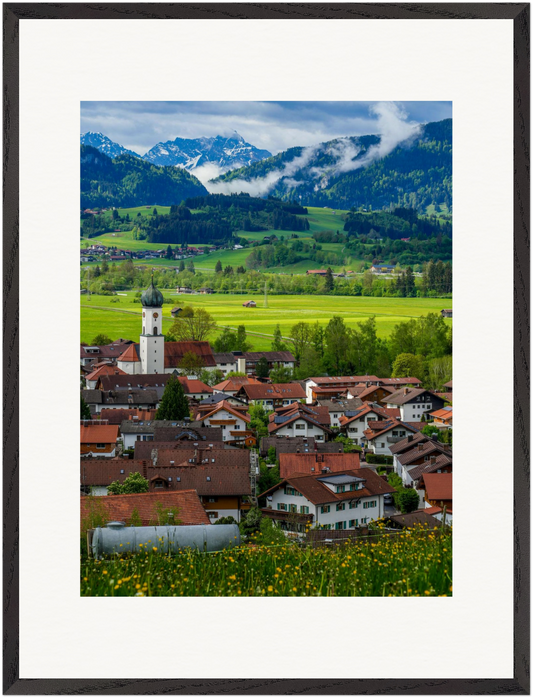 „Allgäu“ – vertikale Kunstfotografie von Stanislav Shnaider. Blick über eine traditionelle Ortschaft im Allgäu mit grünen Wiesen und den Allgäuer Alpen im Hintergrund. Limitierte Fotokunst aus der Alpen-Kollektion im Format 60 × 80 cm.
